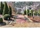 Landscaped backyard featuring a brick pathway leading to a charming white arbor at 2196 Abbott Dr, Buford, GA 30519