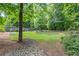 Tranquil backyard with a pebbled area, mature trees, and garden beds, creating a peaceful retreat at 2196 Abbott Dr, Buford, GA 30519