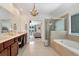 Bathroom with dual vanity, chandelier, soaking tub, and glass shower at 2196 Abbott Dr, Buford, GA 30519
