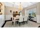 Formal dining room featuring a coffered ceiling, chandelier, wainscoting, and large windows with views at 2196 Abbott Dr, Buford, GA 30519