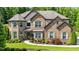 Charming brick home with manicured lawn, fountain, and mature trees creating inviting curb appeal at 2196 Abbott Dr, Buford, GA 30519