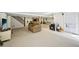 Open basement space has carpeted and tiled flooring, a couch, stairs to the upper floor, and a walkout at 4859 Clark Lake Nw Way, Acworth, GA 30102
