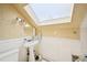 Attic bathroom featuring a skylight, white pedestal sink, decorative lighting, and tiled flooring at 4859 Clark Lake Nw Way, Acworth, GA 30102