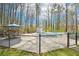 Fenced-in pool area with lounge chairs and patio furniture, shaded by mature trees at 4859 Clark Lake Nw Way, Acworth, GA 30102