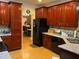 Open-concept kitchen with hardwood floors, cherry wood cabinets, and stainless steel appliances at 1162 Mason Lee, Loganville, GA 30052