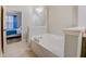 Bright bathroom with white soaking tub and view into a bedroom at 1910 Cedar Glenn Way # 4401, Atlanta, GA 30339