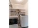 Functional laundry room equipped with modern washer and dryer, and ample storage space on shelving at 23 Peggy Nw Ct, Marietta, GA 30064