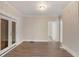 Bright living room featuring wood-look flooring, white wood paneling, and glass paneled french doors at 495 Hutchens Se Rd, Atlanta, GA 30354
