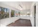 Bright sunroom featuring wood-look flooring, white wood paneling, and large windows showcasing the surrounding trees at 495 Hutchens Se Rd, Atlanta, GA 30354