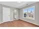Cozy bedroom featuring wood flooring, large window, and en-suite bath at 720 Goldenrod Way, Norcross, GA 30093