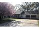 Charming single-story home featuring a two-car garage, covered porch, and blossoming tree in the front yard at 184 Brandywine Dr, Douglasville, GA 30134