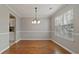 Formal dining room featuring hardwood floors, neutral paint, a chandelier, and a view of the kitchen area at 5706 Spring Mill Cir, Lithonia, GA 30038