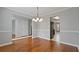 Dining room with hardwood floors, neutral walls, chandelier, and adjacent kitchen space at 5706 Spring Mill Cir, Lithonia, GA 30038
