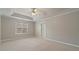 Spacious primary bedroom featuring a tray ceiling, and bright window at 5706 Spring Mill Cir, Lithonia, GA 30038