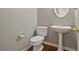 Cozy powder room featuring pedestal sink, oval mirror, and neutral color palette at 5706 Spring Mill Cir, Lithonia, GA 30038