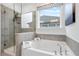 Close-up of a soaking tub and glass shower showcasing modern fixtures and tiled walls at 1465 Auburn Glen Rd, Dacula, GA 30019
