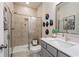 Modern bathroom featuring a glass-enclosed shower, gray vanity, and stylish fixtures at 1465 Auburn Glen Rd, Dacula, GA 30019