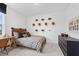 Well-lit bedroom with dark wood accents, plaid bedding, and football decor at 1465 Auburn Glen Rd, Dacula, GA 30019