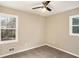 A bedroom featuring neutral walls, carpeted floor, a ceiling fan, and two windows at 1643 Pine Glen Cir, Decatur, GA 30035