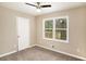 A bedroom with carpet, neutral walls, ceiling fan, window overlooking a deck, and a white door at 1643 Pine Glen Cir, Decatur, GA 30035