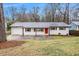 Charming single-story home featuring a brick facade, red door, and well-maintained front yard at 1643 Pine Glen Cir, Decatur, GA 30035