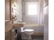 Compact bathroom features a classic design with a toilet, sink, and a bathtub with shower at 2791 Pearl St, East Point, GA 30344