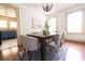 View of the dining room with hardwood floors, neutral walls and light-filled windows next to the kitchen at 2791 Pearl St, East Point, GA 30344