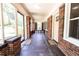 Long front porch with brick walls, windows, and two black and white rugs at 2791 Pearl St, East Point, GA 30344