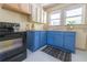 This cozy kitchen features bright blue cabinets and white countertops with a black oven at 2791 Pearl St, East Point, GA 30344