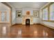 Cozy living room featuring a fireplace and hardwood flooring with two windows for natural light at 2791 Pearl St, East Point, GA 30344