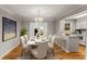 Dining room features hardwood floors, modern chandelier, and kitchen bar seating at 6700 Roswell Rd # 15B, Atlanta, GA 30328