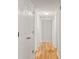 A well-lit hallway featuring hardwood floors and multiple closet doors for storage and organization at 6700 Roswell Rd # 15B, Atlanta, GA 30328