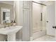 Elegant bathroom featuring a pedestal sink, glass-enclosed shower, and modern fixtures at 714 Billings Farm Ln, Canton, GA 30115