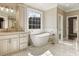 Luxurious bathroom with a standalone tub, marble floors, and natural light from a window at 714 Billings Farm Ln, Canton, GA 30115