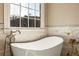 Spa-like bathroom featuring a standalone tub, large window, and modern fixtures at 714 Billings Farm Ln, Canton, GA 30115