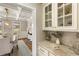 Charming butler's pantry featuring elegant cabinetry, stone countertops, and stylish decor leading to dining area at 714 Billings Farm Ln, Canton, GA 30115