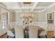 Elegant dining room featuring coffered ceiling, stylish chandelier, and wainscoting creates a sophisticated ambiance at 714 Billings Farm Ln, Canton, GA 30115