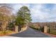 Long private driveway leading to a stately home, framed by mature trees and lush greenery at 714 Billings Farm Ln, Canton, GA 30115