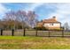 Home exterior featuring manicured lawn and fenced yard with trees in background at 714 Billings Farm Ln, Canton, GA 30115