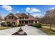 Beautiful brick home featuring a circular driveway with a fountain, complemented by lush landscaping at 714 Billings Farm Ln, Canton, GA 30115