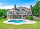 Stunning rear exterior with an in-ground pool and lush landscaping creates an inviting outdoor oasis at 714 Billings Farm Ln, Canton, GA 30115