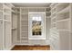 Organized walk-in closet with custom shelving, a built-in window seat, and hardwood floors for optimal storage at 714 Billings Farm Ln, Canton, GA 30115
