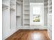 Spacious walk-in closet with custom shelving, hardwood floors, and natural light from a window at 714 Billings Farm Ln, Canton, GA 30115