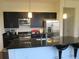 Modern kitchen with stainless steel appliances, a large island, and sleek, dark cabinetry at 333 Nelson Sw St # 214, Atlanta, GA 30313