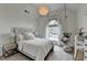 Stylish bedroom with a hanging chair by a large window, complemented by elegant décor and soft lighting at 3350 Vista Creek Dr, Dacula, GA 30019