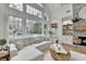 Cozy living room with large windows offering great views, a fireplace, and comfortable white sofas at 3350 Vista Creek Dr, Dacula, GA 30019