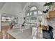 Open-concept living area with stone fireplace, pool view, kitchen and dining areas, and white sofas at 3350 Vista Creek Dr, Dacula, GA 30019