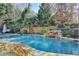 Inviting in-ground pool with a relaxing waterfall feature, surrounded by a lush landscaped yard at 3350 Vista Creek Dr, Dacula, GA 30019