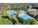 Aerial view showcasing multiple blue and green tennis courts surrounded by lush greenery and trees at 3350 Vista Creek Dr, Dacula, GA 30019