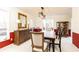 Dining room featuring a long, wooden table, unique light fixture, and a red accent wall at 1511 Womack Rd, Atlanta, GA 30338